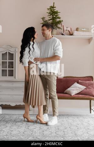 Beau homme et jeune jolie femme passent du temps à la maison la veille de Noël Banque D'Images