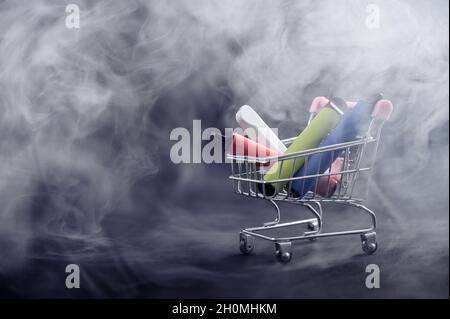 Vapes jetables dans un panier sur fond noir.Cigarettes électroniques modernes. Banque D'Images