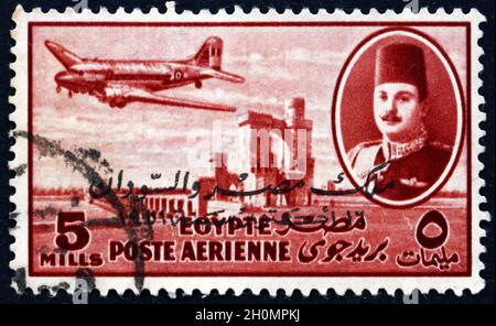 ÉGYPTE - VERS 1947 : un timbre imprimé en Égypte montre le roi Farouk, le barrage Delta et l'avion DC-3, vers 1947 Banque D'Images