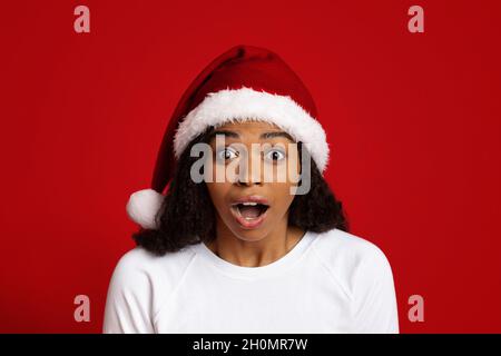 Gros plan sur une dame noire surprise dans un chapeau de père noël Banque D'Images