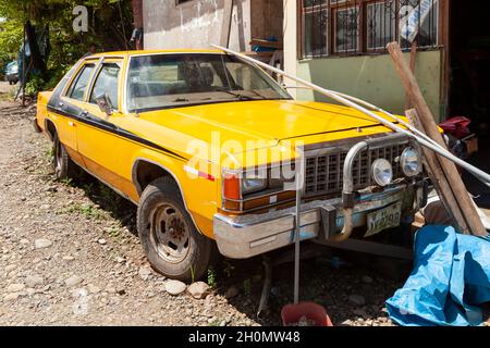 Pilcopata, Pérou - 10 avril 2014 : une vieille et grande voiture jaune, se trouve garée dans les environs de la petite ville de Pilcopata Banque D'Images