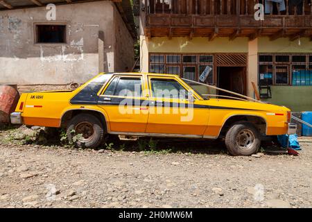 Pilcopata, Pérou - 10 avril 2014 : une vieille et grande voiture jaune, se trouve garée dans les environs de la petite ville de Pilcopata Banque D'Images