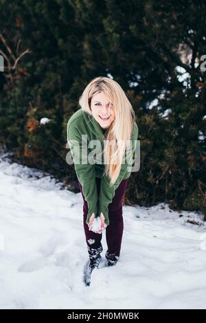 Blonde scandinave avec les yeux bleus en hiver dans le parc rires se préparer à jeter la neige Banque D'Images