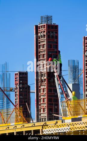 Ouvriers de la construction assemblant des coffrages pour colonnes de béton sur le chantier de construction Banque D'Images