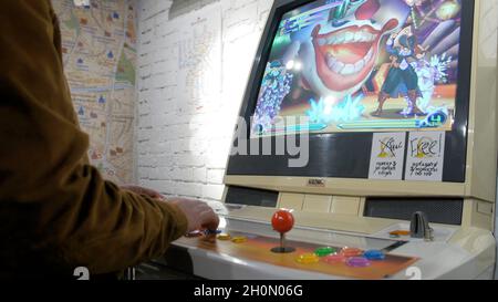 Homme jouant à l'ancienne console de jeu.Joystick d'un jeu vidéo d'arcade vintage - coin-Op.Gros plan de l'homme jouant à des jeux d'arcade avec le joystick sur les vieux inconvénients Banque D'Images