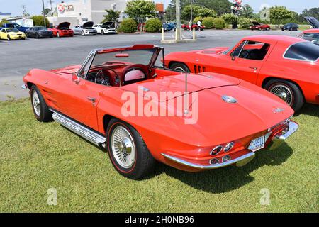 Une Corvette cabriolet rouge des années 60 de Chevrolet présente un salon de l'auto. Banque D'Images