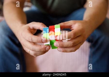 Moscou Russie 10 octobre 2021.Les mains masculines tenant le cube de Rubik gros plan sur le cube de Rubik inventé par un architecte hongrois Erno Rubik en 1974. Banque D'Images