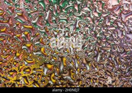 Photo macro des gouttes d'eau colorées sur le verre.Arrière-plan abstrait. Banque D'Images
