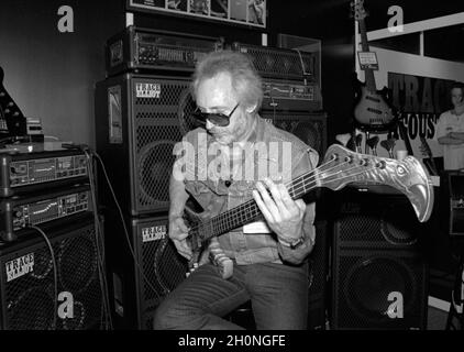 Le guitariste de basse anglaise John Entwistle joue un instrument très orné sur un stand à la British Music Fair, Olympia, Londres, Angleterre en 1991. Banque D'Images