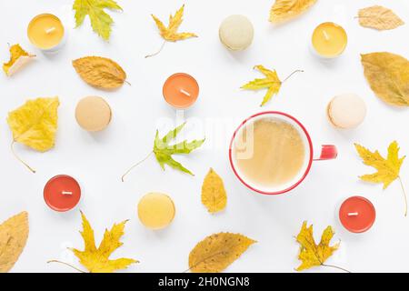 Planéité d'automne.Feuilles jaunes, bougies, tasse de café et macarons sur fond blanc.Concept d'automne.Flat lay, vue de dessus Banque D'Images