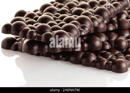 Pile de barres de chocolat noir brut sur fond blanc. Isoler. Banque D'Images