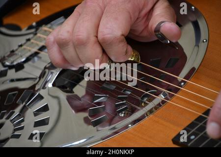 La main masculine joue le Dobro pour la musique de bluegrass. Banque D'Images