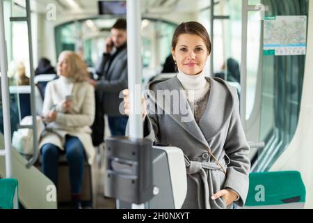 Portrait d'une femme positive voyageant en tramway Banque D'Images
