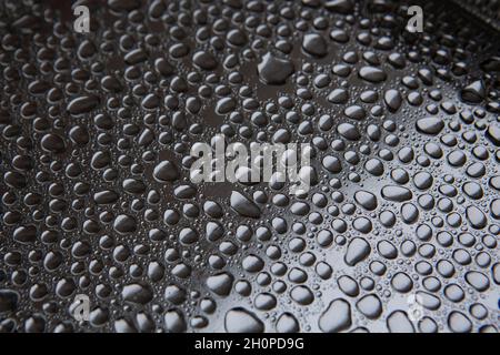 Gouttes d'eau la pluie tombe sur un plateau en métal argenté Banque D'Images