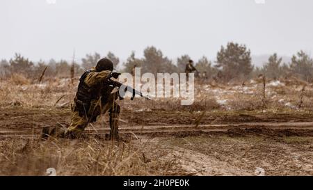 Un officier de l'OMON (police anti-émeute) signale une direction dangereuse à l'unité pendant la phase de terrain de l'exercice.Un exercice tactique et spécial complexe a eu lieu dans la région de Voronezh.Y ont assisté des employés et des militaires de la Garde nationale et des bureaux régionaux des services de l'électricité de l'État. Banque D'Images