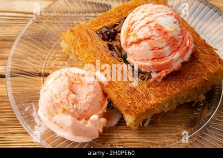 Dessert turc kunefe servi avec de la crème glacée sur fond de bois Banque D'Images