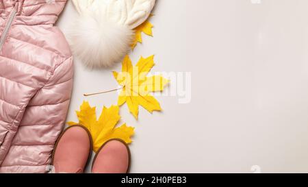 Un ensemble de vêtements chauds automne-hiver pour une fille sur fond gris clair.Veste chapeau chaussures.Espace de copie de la vue de dessus de la pose à plat Banque D'Images