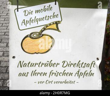 11 octobre 2021, Saxe, Fuchshain BEI Leipzig: Devant un broyeur mobile de pommes, que le jardin de Leipzig et le paysagiste Andreas Richter ont installé pour une journée sur une ferme à Fuchshain près de Leipzig, il y a un panneau pour le broyeur de pommes.Devant les yeux des clients, la petite usine de fruits sur roues va transformer les fruits riches en vitamines en jus direct naturellement nuageux à divers endroits jusqu'à la fin du mois d'octobre et peut ensuite être emmenée chez elle dans un emballage de 5 litres.Avec la cidery mobile, Andreas Richter veut contribuer à la préservation, mais aussi à la replantation de sp Banque D'Images