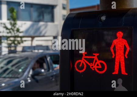 Figure rouge et vélo sur une traversée pour piétons.Ne pas croiser l'affiche. Banque D'Images