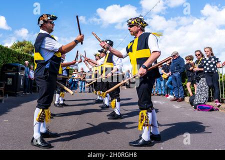 Vue à angle bas regardant le long de deux Rows of Wantsum Morris hommes dansant avec le personnel en bois dans leurs mains au festival de la semaine folklorique de Broadstairs.Ciel bleu. Banque D'Images