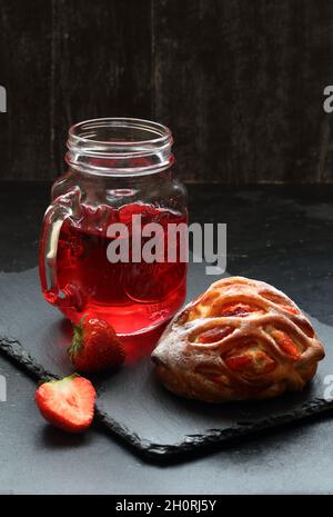 Brioche avec fraises et fromage cottage avec jus de cerise sur fond noir Banque D'Images