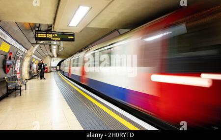 Train métro de Londres (le métro) arrivant à la vitesse de la gare de Knightsbridge, en direction de Heathrow ; flou dû à une longue exposition, vitesse d'obturation lente Banque D'Images