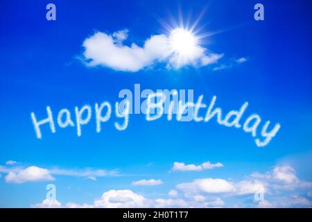 Joyeux anniversaire écrit sur un ciel bleu ensoleillé, symbole de meilleurs voeux pour une journée spéciale sans souci avec un soleil sans fin.Modèle d'arrière-plan. Banque D'Images