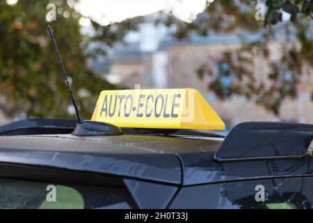 Panneau jaune de toit de voiture avec écrit en français 'Auto-École', signifiant en anglais 'Driving School'. Banque D'Images