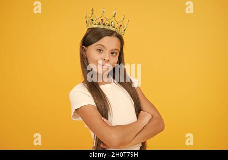 Jeune perfectionniste. Fier de sa récompense. luxe et succès. Petite fille égoïste porte couronne dorée. Petite fille princesse. Se sentir champion. Heureux Banque D'Images