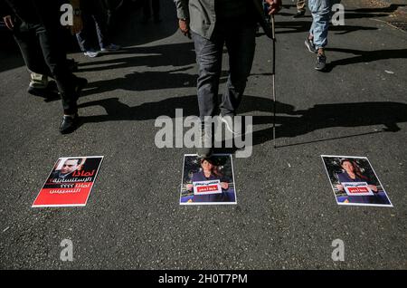 Beyrouth, Liban.14 octobre 2021.Un militant chiite musulman fait un pas sur la photo de l'ambassadeur américain au Liban Dorothy Shea lors d'une manifestation des partisans pro-iraniens du Hezbollah contre le juge enquêtant sur l'explosion portuaire de la ville, près de la ligne de front de l'ancienne guerre civile entre les zones chiite et chrétienne.Au moins six personnes ont été tuées et 30 blessées à Beyrouth alors que des coups de feu ont éclaté lors d'une manifestation contre le juge qui enquêtait sur l'explosion du port de la ville l'année dernière, a déclaré la Croix-Rouge libanaise.Credit: Marwan Naamani/dpa/Alamy Live News Banque D'Images