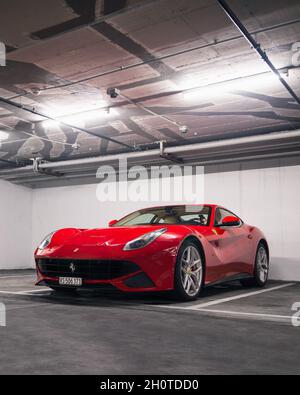 Red Ferrari F12 Berlinetta Supercar dans un parking souterrain au centre de Genève, Suisse. Banque D'Images