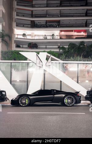 Voiture Porsche 918 Spyder noire mate garée dans un restaurant de luxe dans le centre de Monaco. Banque D'Images