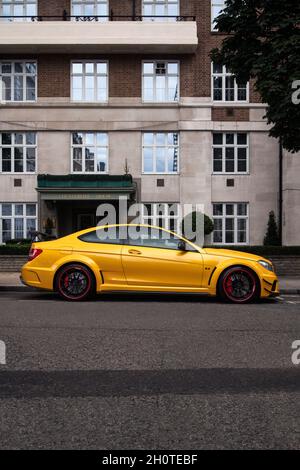 Jaune Mercedes-Benz C63 AMG coupé de performance de la série Black garée dans une rue du quartier de Mayfair dans le centre de Londres, en Angleterre. Banque D'Images