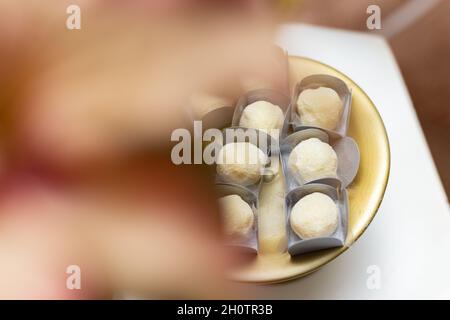 Détail des bonbons faits de lait en poudre et roulés, disposés à l'intérieur d'un plateau, sur la table de fête. Banque D'Images