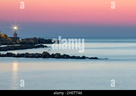 Paysage marin avec phare et rochers à l'aube Banque D'Images
