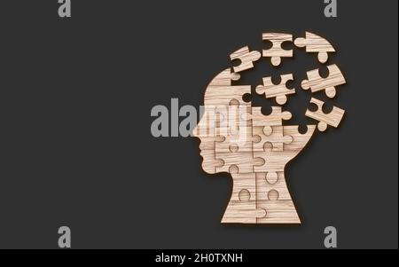 Symbole de santé mentale.Silhouette de la tête humaine avec un puzzle coupé à partir d'un fond en bois. Banque D'Images