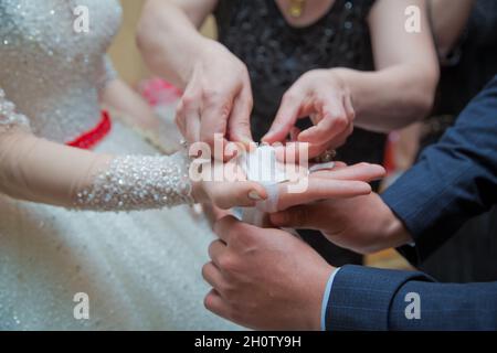 La mariée met le mouchoir dans ses mains .La main de la mariée est attachée à l'arc Banque D'Images