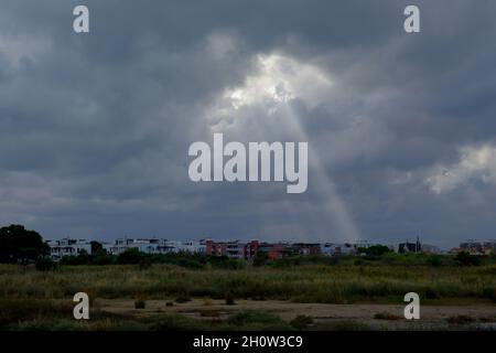 Un ciel orageux avec des nuages noirs et un rayon de soleil filtrant à travers une bande de ciel Banque D'Images