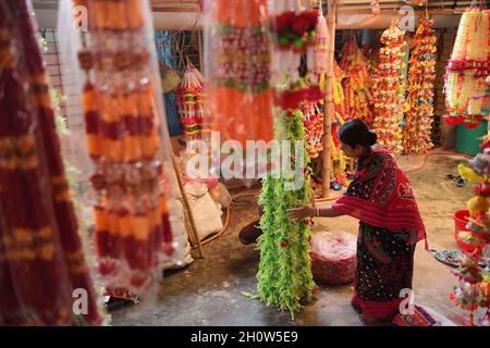 Les gens organisent et font des guirlandes en vente faites de différents types de plastique dans une usine de guirlandes, avant le Festival de Durga Puja dans la banlieue d'Agartala.Agartala, Tripura, Inde. Banque D'Images