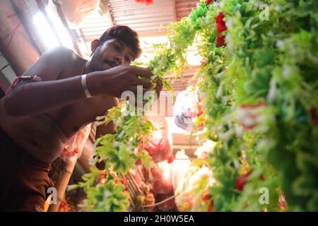 Les gens organisent et font des guirlandes en vente faites de différents types de plastique dans une usine de guirlandes, avant le Festival de Durga Puja dans la banlieue d'Agartala.Agartala, Tripura, Inde. Banque D'Images