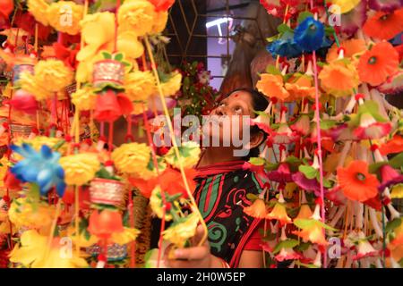 Les gens organisent et font des guirlandes en vente faites de différents types de plastique dans une usine de guirlandes, avant le Festival de Durga Puja dans la banlieue d'Agartala.Agartala, Tripura, Inde. Banque D'Images