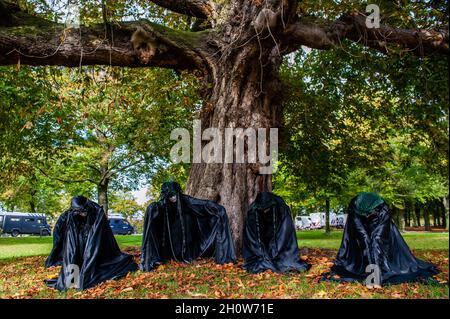 La Haye, pays-Bas.14 octobre 2021.Les rebelles noirs se présentent dans un parc en face d'un arbre.Dans le cadre de la nouvelle campagne de rébellion contre l'extinction Climate Rebellion, des centaines de militants du climat ont marché dans des vêtements noirs autour du centre de la Haye comme une procession funéraire pour honorer la mémoire des victimes du changement climatique et de la crise écologique.Le cortège silencieux était dirigé par les rebelles noirs et passé par plusieurs bureaux politiques du parti dans la ville.Crédit : SOPA Images Limited/Alamy Live News Banque D'Images