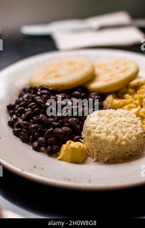 Petit déjeuner créole de type vénézuélien avec céréales, œufs brouillés et fromage blanc râpé Banque D'Images