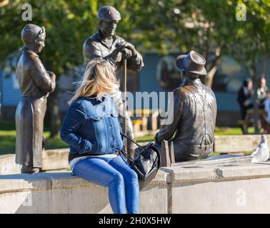 Femme d'âge moyen assise sur un banc dans le parc.Vue sur la rue, photo de voyage, mise au point sélective.Octobre 11,2021.Richmond, C.-B., Canada Banque D'Images