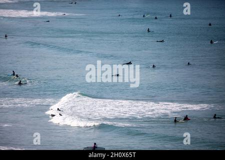 Une vue sur les personnes marchant et surfant sur la plage de Fistral à Newquay, Cornwall, Royaume-Uni Banque D'Images