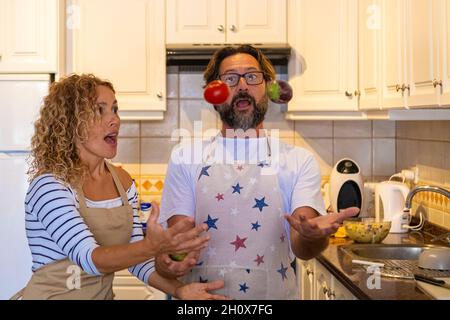 Couple dans la cuisine ont drôle de temps d'activité de loisirs avec jouer avec la nourriture pendant la préparation du déjeuner.Un homme et une femme heureux s'amusent à la maison Banque D'Images