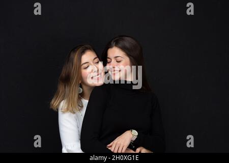 Deux beaux amis qui s'embrasent les uns les autres.Deux sœurs se donnant l'amour.Couple de filles s'aimant.Concept d'amour Banque D'Images