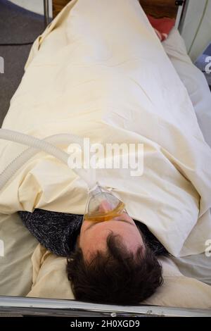 KIEV, UKRAINE - 12 octobre 2021: Les activistes se présentent sur une scène de service de réanimation temporaire pour les patients COVID-19.Homme avec masque à oxygène Banque D'Images