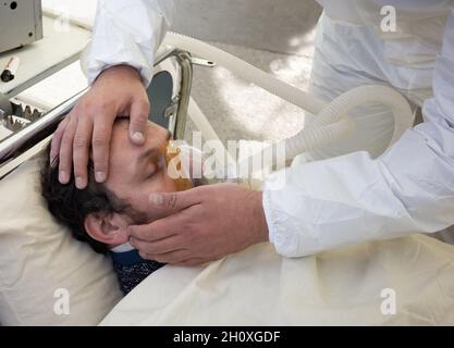 KIEV, UKRAINE - 12 octobre 2021: Les activistes se présentent sur une scène de service de réanimation temporaire pour les patients COVID-19.Homme avec masque à oxygène Banque D'Images