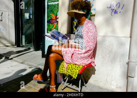 Magazine afro-américain de lecture de femme, Valencia Street Scene Espagne Banque D'Images